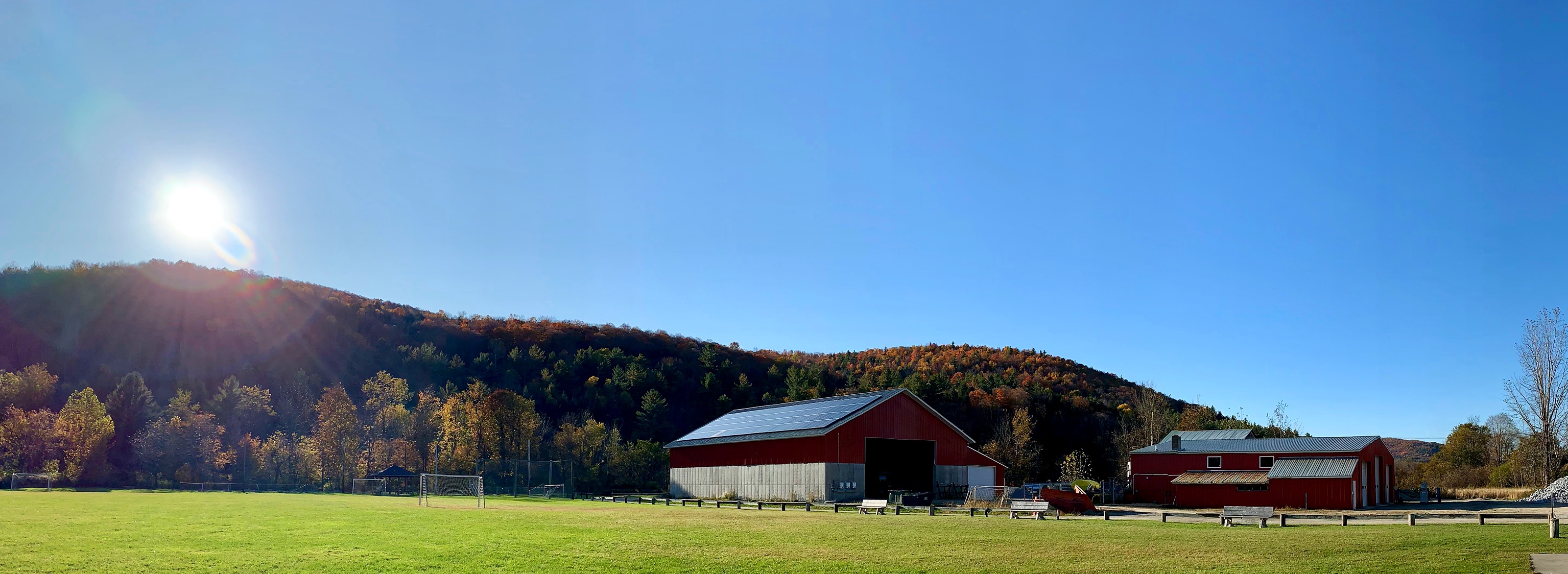 Barn with solar panels on roof at the foothill of a mountain