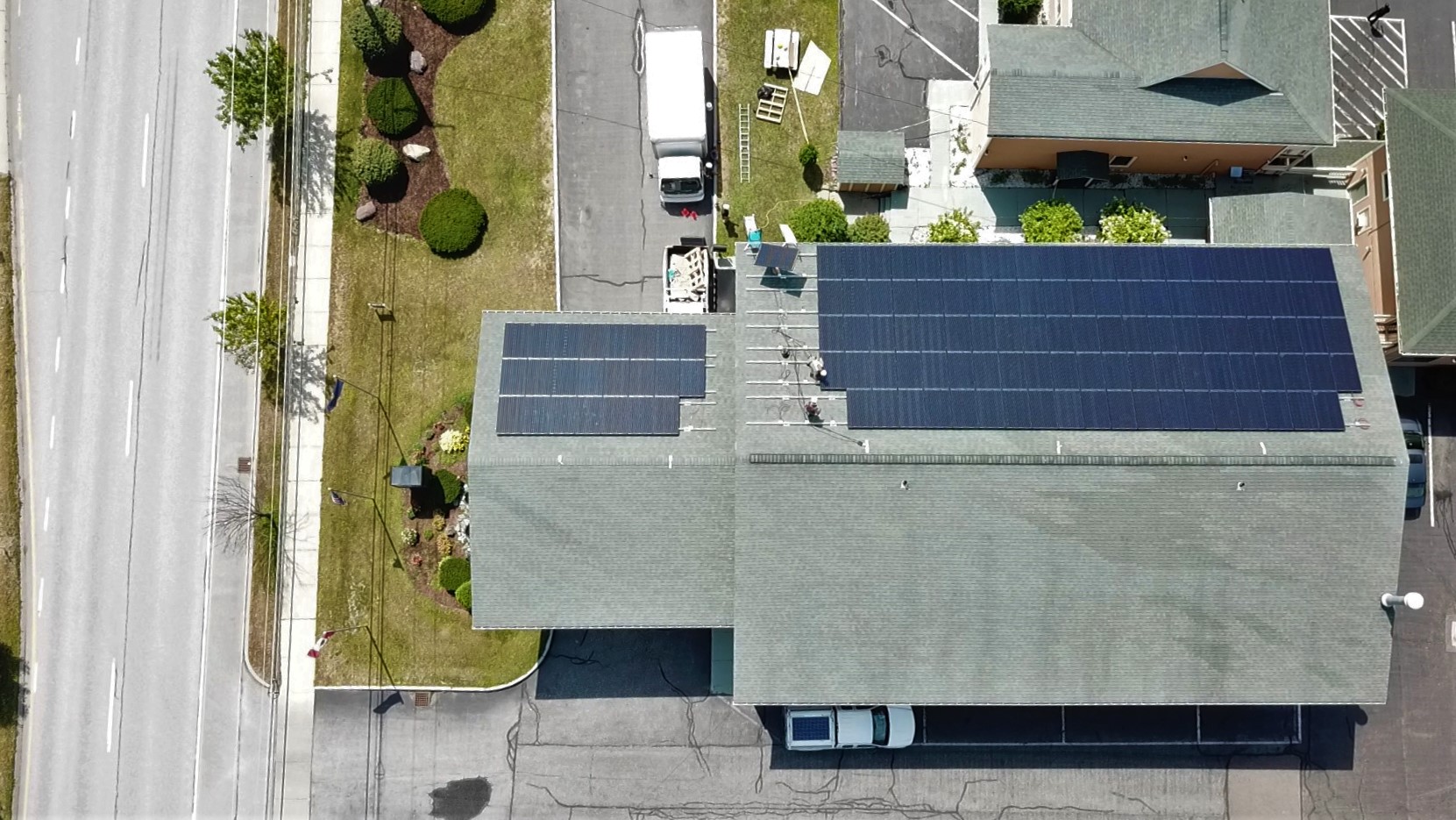 Ariel view of solar panels being installed on top of a hotel roof