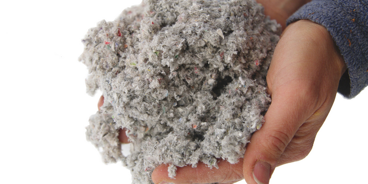 An image of someone holding a handful of Loose Fill Insulation.